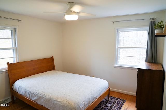 bedroom with light wood-type flooring, baseboards, and a ceiling fan