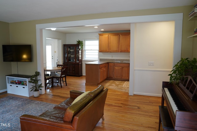 living room with recessed lighting, baseboards, and light wood-style flooring