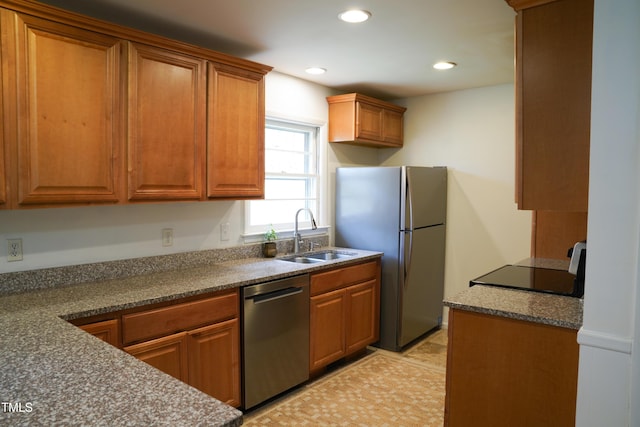 kitchen with a sink, stainless steel appliances, recessed lighting, and brown cabinetry