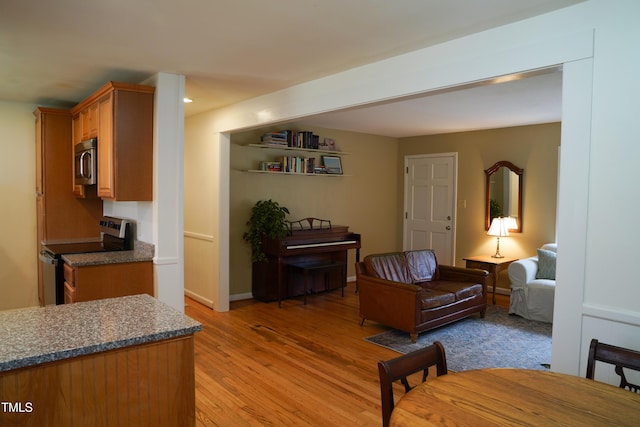 living area featuring recessed lighting, light wood-style floors, and baseboards