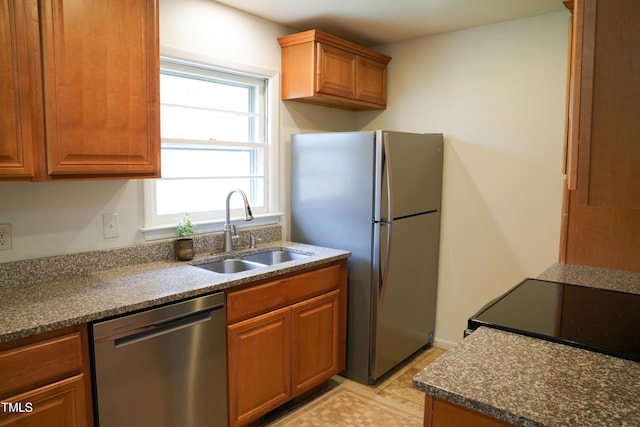 kitchen with a sink, brown cabinetry, and stainless steel appliances