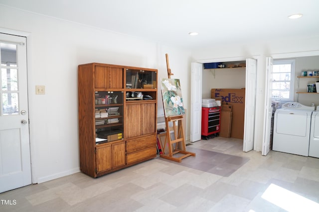 interior space featuring recessed lighting, light floors, baseboards, and washing machine and clothes dryer