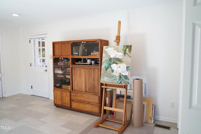 interior space with visible vents, brown cabinets, light floors, and baseboards