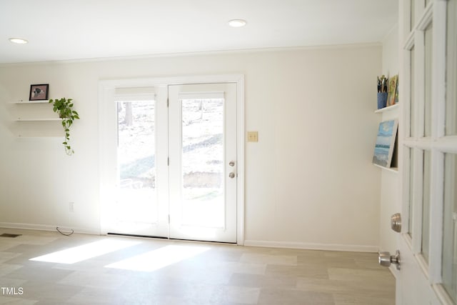 entryway featuring wood finished floors, recessed lighting, baseboards, and ornamental molding