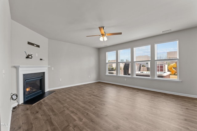 717 Tailrace Falls Ct, Wake Forest, NC 27587 - unfurnished living room featuring ceiling fan, dark wood-style flooring, baseboards, and a glass covered fireplace