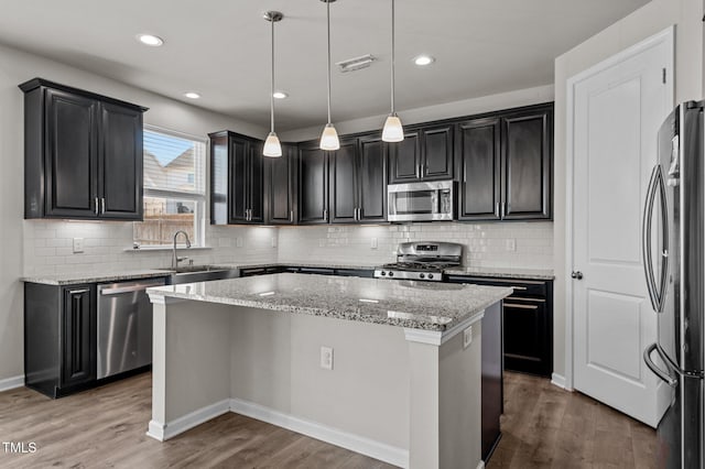 717 Tailrace Falls Ct, Wake Forest, NC 27587 - kitchen with stainless steel appliances, a sink, a center island, wood finished floors, and recessed lighting