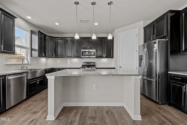 717 Tailrace Falls Ct, Wake Forest, NC 27587 - kitchen with stainless steel appliances, a center island, dark cabinets, and recessed lighting