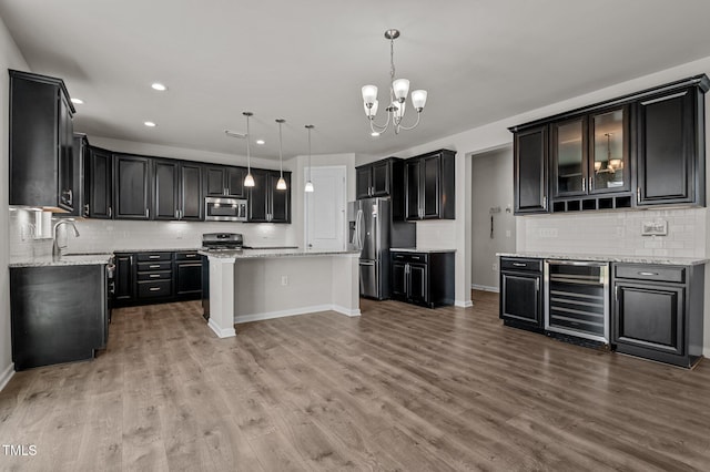 717 Tailrace Falls Ct, Wake Forest, NC 27587 - kitchen featuring beverage cooler, stainless steel appliances, a center island, backsplash, and recessed lighting