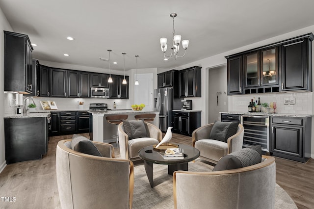 717 Tailrace Falls Ct, Wake Forest, NC 27587 - living area with wine cooler, light wood finished floors, a chandelier, recessed lighting, and bar