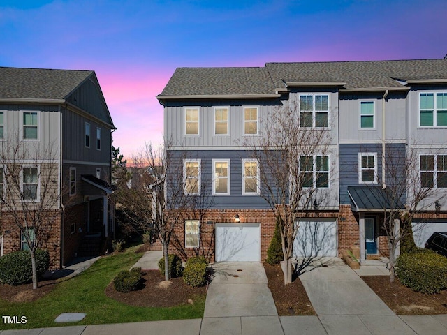 townhome / multi-family property featuring board and batten siding, concrete driveway, brick siding, and an attached garage