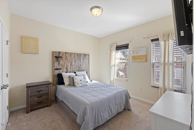 bedroom featuring light colored carpet and baseboards