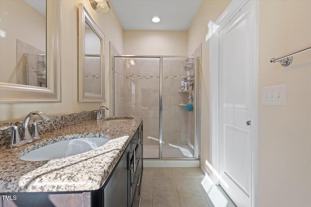 full bath with a sink, a shower stall, and tile patterned floors