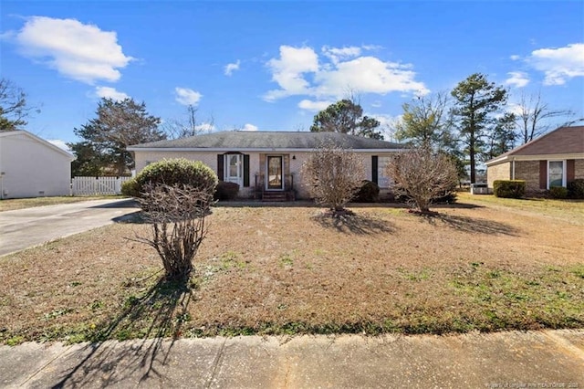 ranch-style home featuring concrete driveway and fence