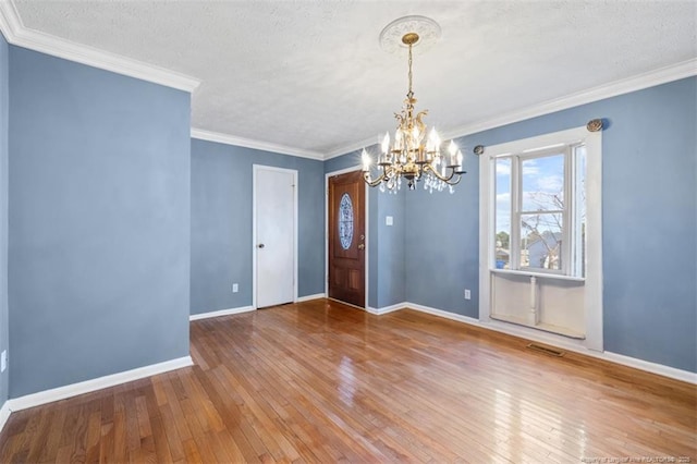 interior space featuring a notable chandelier, baseboards, visible vents, and hardwood / wood-style floors