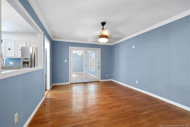 interior space featuring light wood-style floors, baseboards, and ornamental molding