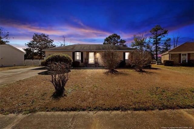 ranch-style house featuring concrete driveway and fence