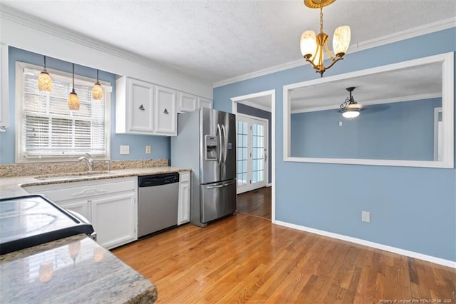 kitchen with a textured ceiling, stainless steel appliances, white cabinetry, light wood finished floors, and crown molding