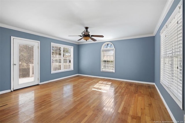 unfurnished room featuring a ceiling fan, wood-type flooring, ornamental molding, and baseboards