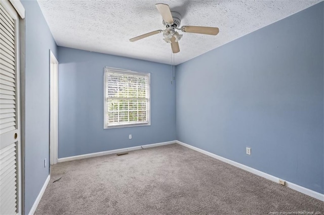 unfurnished bedroom with visible vents, baseboards, a textured ceiling, carpet flooring, and a closet