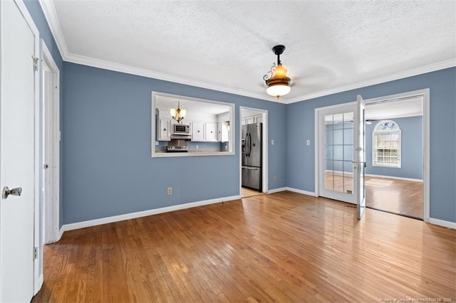 interior space with hardwood / wood-style flooring, crown molding, and a textured ceiling