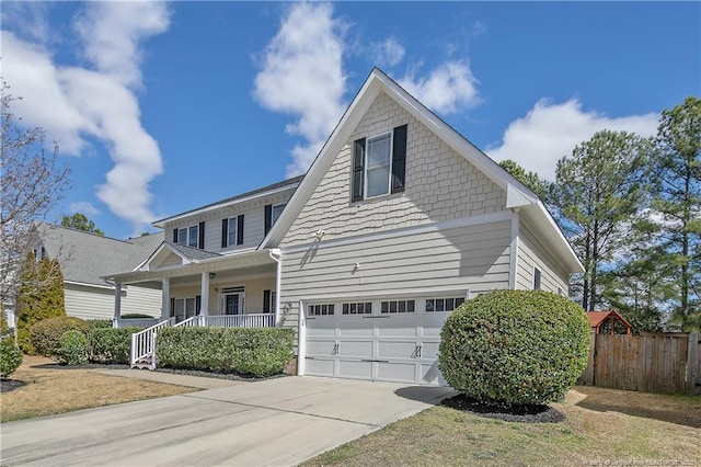 view of front of home with an attached garage, covered porch, fence, and concrete driveway