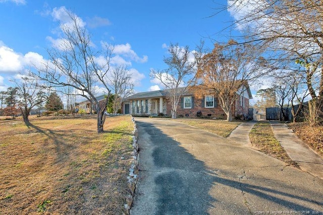 view of front of house featuring driveway, brick siding, and crawl space