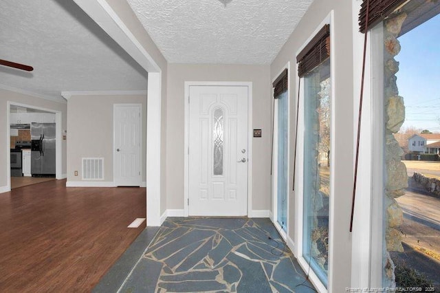 foyer entrance featuring baseboards, visible vents, wood finished floors, crown molding, and a textured ceiling