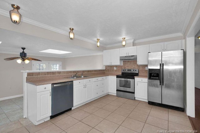 kitchen featuring tasteful backsplash, appliances with stainless steel finishes, white cabinets, a peninsula, and under cabinet range hood