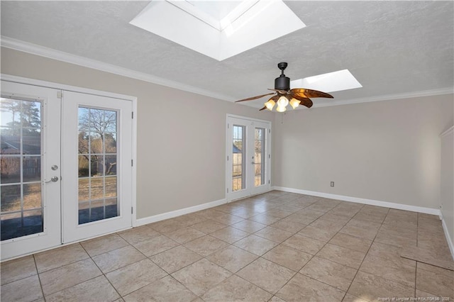 spare room featuring a skylight, ornamental molding, a textured ceiling, and french doors