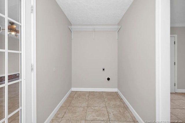 laundry room featuring laundry area, electric dryer hookup, baseboards, and a textured ceiling