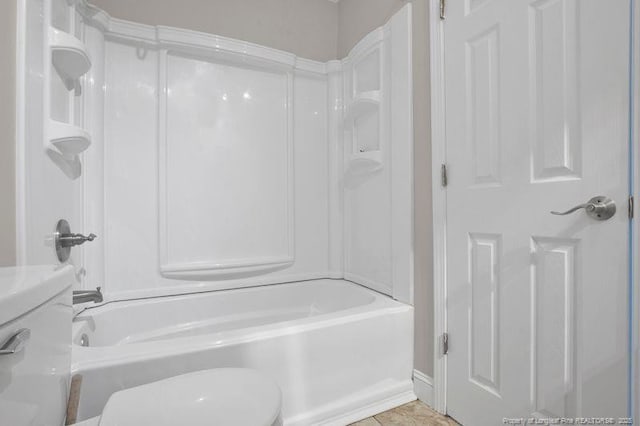 bathroom with shower / bathing tub combination, toilet, and tile patterned floors