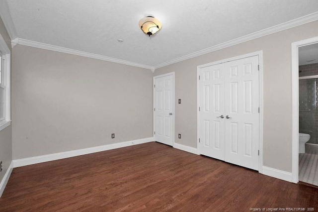 unfurnished bedroom featuring ornamental molding, dark wood-style flooring, and baseboards