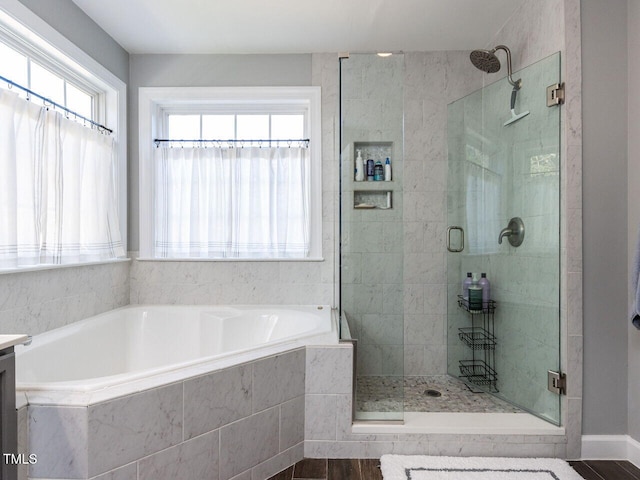 bathroom with a shower stall, a bath, and a wealth of natural light