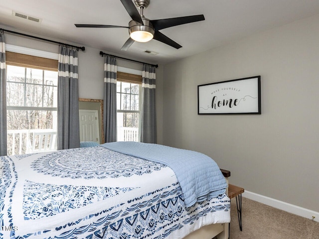 carpeted bedroom with visible vents, baseboards, and ceiling fan