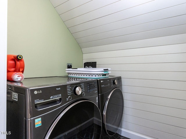 clothes washing area featuring wooden ceiling, washing machine and dryer, laundry area, and wood walls