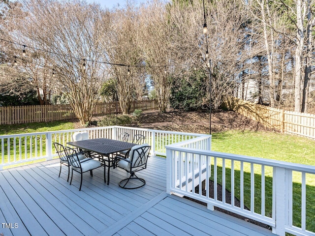 wooden terrace with outdoor dining area, a yard, and a fenced backyard