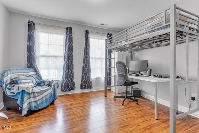 bedroom featuring baseboards and wood finished floors