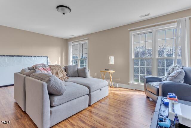 living room with visible vents and wood finished floors