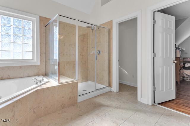 full bath featuring a stall shower, tile patterned floors, and a bath