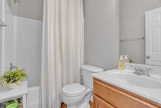 bathroom featuring shower / tub combo with curtain, vanity, and toilet