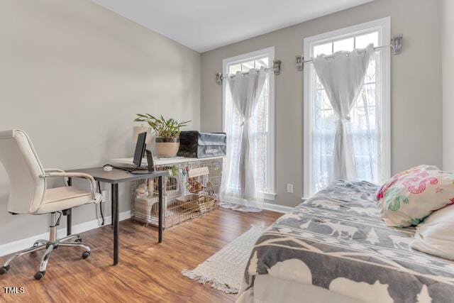 bedroom with baseboards and wood finished floors