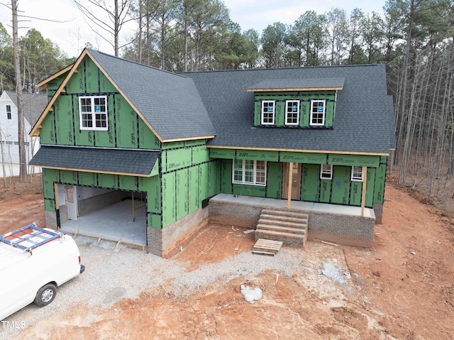 property in mid-construction featuring a carport, a porch, and a shingled roof