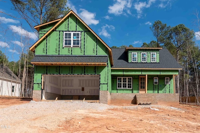 unfinished property with covered porch, a shingled roof, and a garage