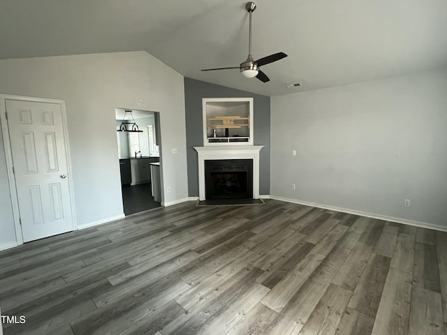 unfurnished living room featuring baseboards, dark wood finished floors, a ceiling fan, lofted ceiling, and a fireplace with flush hearth