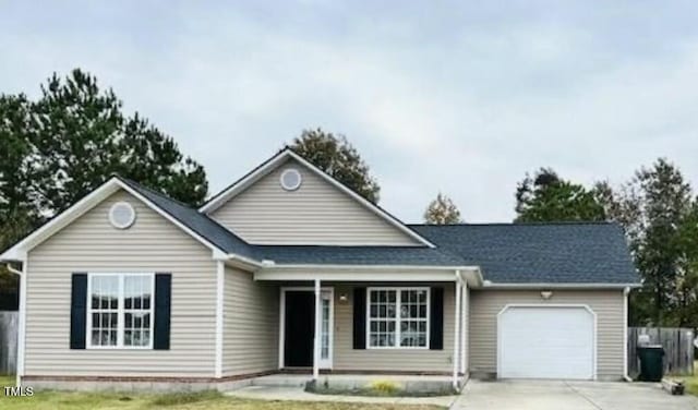 view of front facade featuring concrete driveway, covered porch, and an attached garage