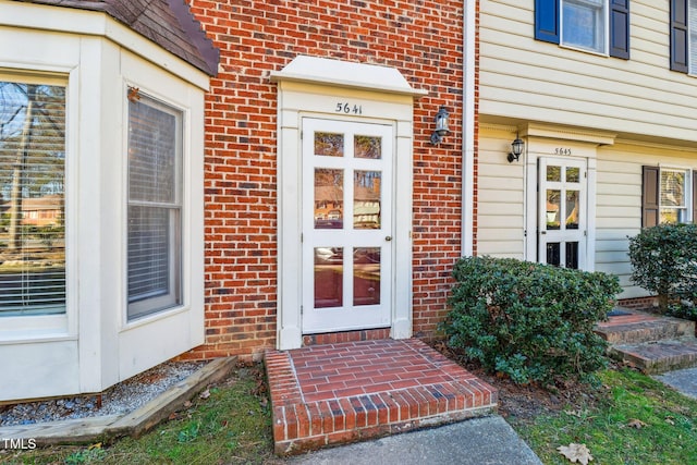 entrance to property featuring brick siding