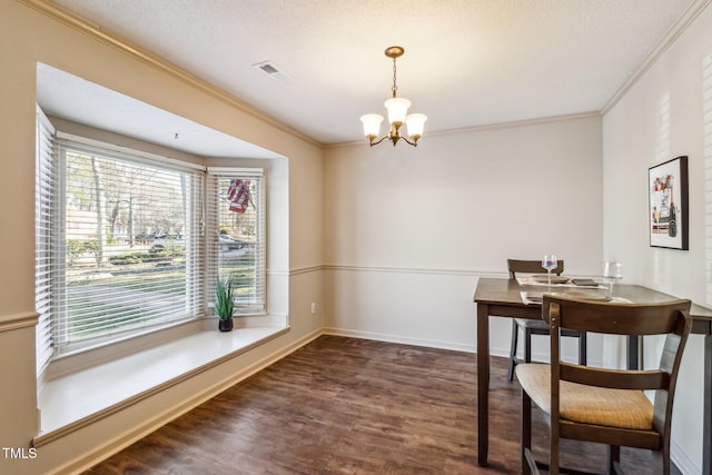 dining room featuring a chandelier, wood finished floors, visible vents, baseboards, and ornamental molding