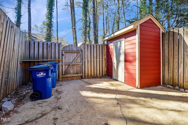 view of shed featuring a fenced backyard and a gate