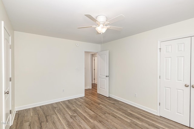 unfurnished bedroom featuring a ceiling fan, wood finished floors, and baseboards