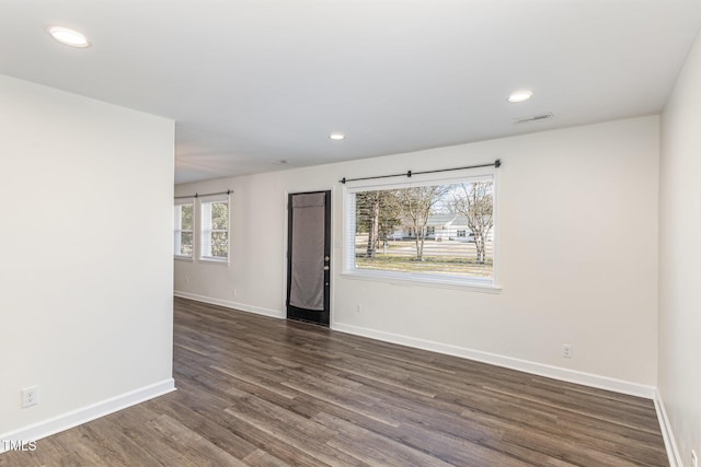 unfurnished room featuring dark wood-type flooring, recessed lighting, baseboards, and visible vents